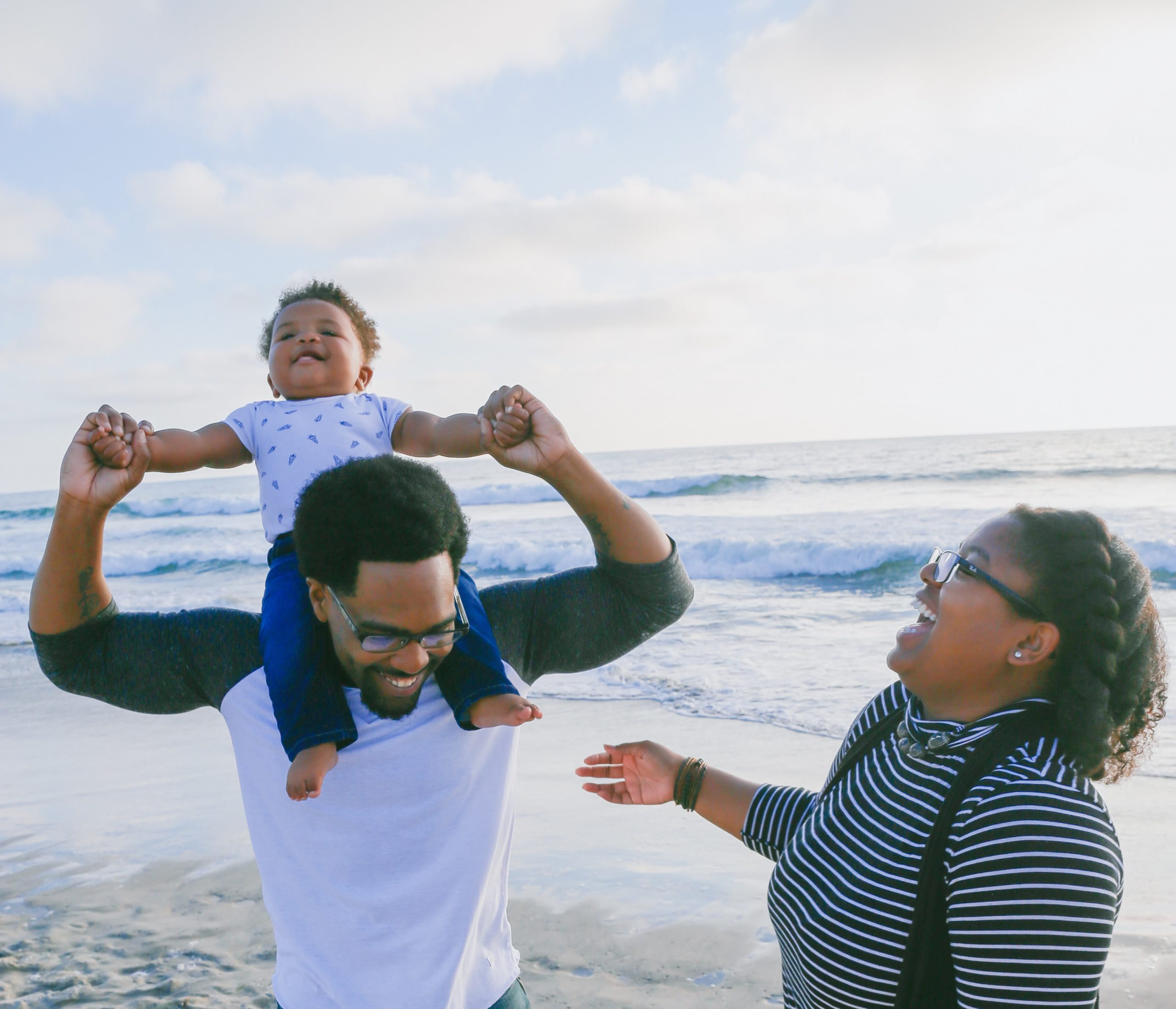 Parents and toddler having fun at the beach. Click on the Image to learn more about BCA Adult Ministries - Family Life.
