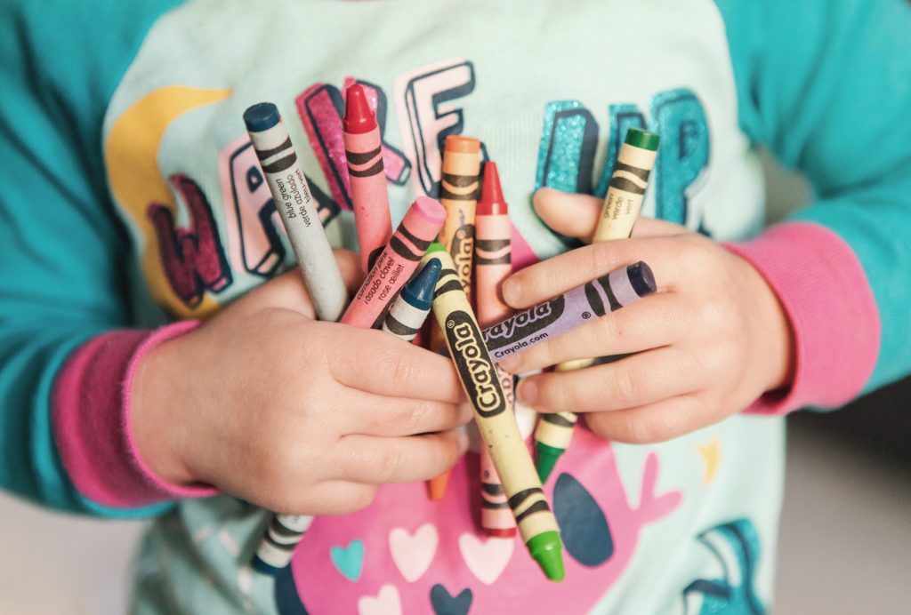 Toddler with a handful of crayons