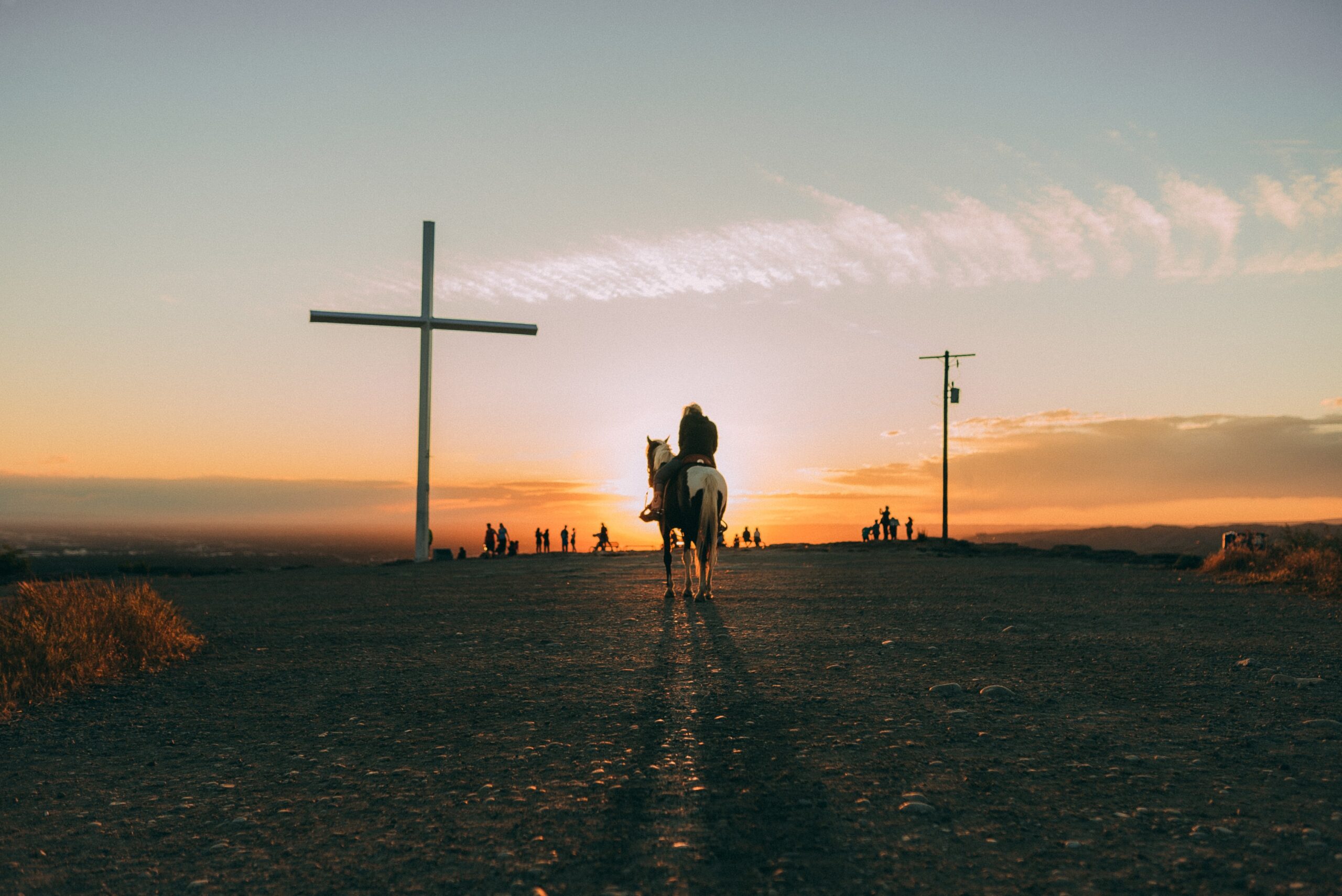 A man on a horse near a cross