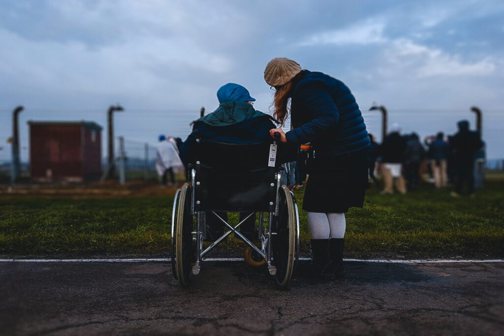 Woman helping an elderly man in a wheelchair